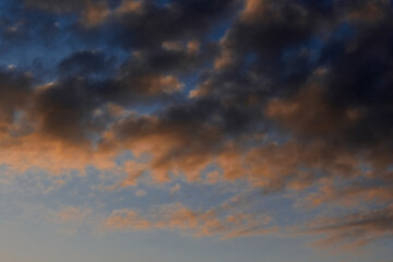 Heavenly landscape background with the texture of clouds at sunset. Beautiful morning sky in blue and orange colors. 