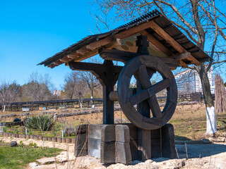Obraz premium Old wooden well with a large wooden wheel.