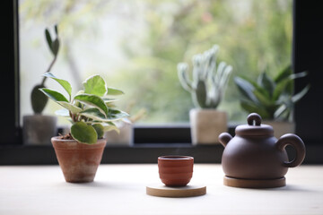 Wooden tea cup with oriental tea pot and notebook with plant pot