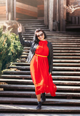 Naklejka premium A young girl in a red dress shows a Victorian sign. feminism