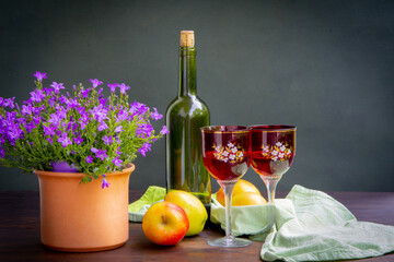 Antique stylized still life with a bouquet of roses, a bottle of wine and apples.