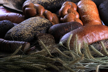 Still life with different types of bread: black, rye, white bread, bread with seeds. bread and wheat ears. 