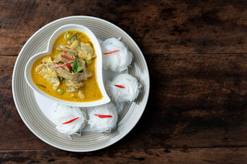 Top view Thai food Green curry pork in Heart shaped plate and Rice noodles on old wood background.
