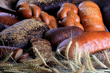 Still life with different types of bread: black, rye, white bread, bread with seeds. bread and wheat ears. 
