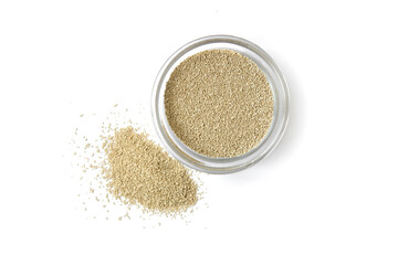 dry yeast in a glass bowl on a white isolated background, top view