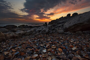 Russia. Dagestan. Dawn on the seashell-strewn rocky shore of the Caspian Sea near the city embankment of Makhachkala.