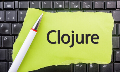 Clojure Programming Language. Word Clojure on paper and laptop 