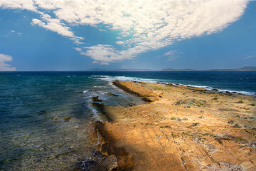 Sharp rocks, from sedimentary rocks in the stormy sea with the cloudy sky