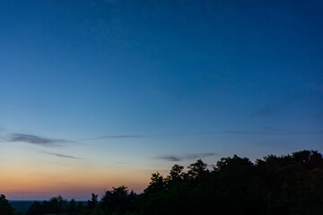 twilight over the tops of the trees and the blue sky landscape of the countryside.
