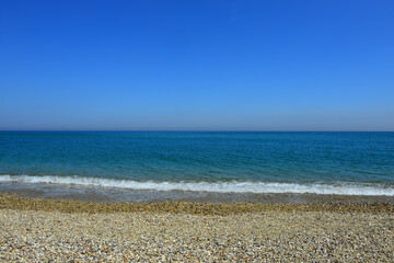 pebbly seascape, background blue clouds. Pruva Beach, Istanbul.