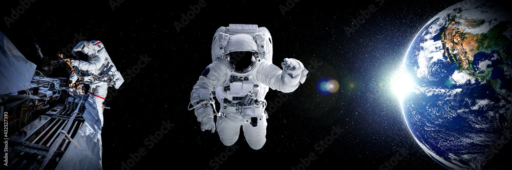 Wall mural astronaut spaceman do spacewalk while working for space station in outer space . astronaut wear full
