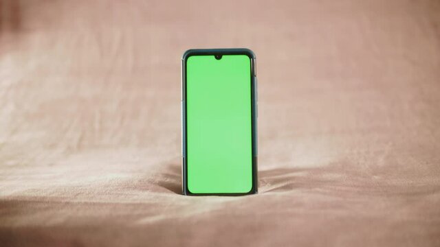 smartphone avec fond vert sur fond isol&eacute; blanc cass&eacute;