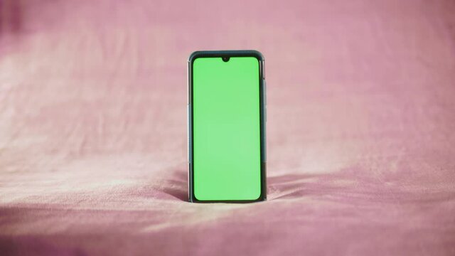 smartphone avec fond vert sur fond isol&eacute; rose