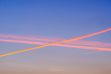 Fototapeta na wymiar Traffic in the air. Crossing condensation trails at sunset