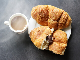 Cappuccino and croissant on black background