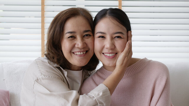 Close up attractive beautiful two asia people face cheek smile to camera authentic real family mum and adult kid in woman power day, diverse ethnic people, genes genetics ginger mom skincare concept.