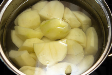 Boil the potatoes in a saucepan. Peeled potatoes in water. Home cooking