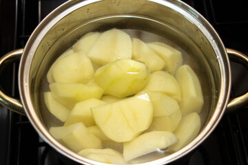 Boil the potatoes in a saucepan. Peeled potatoes in water. Home cooking