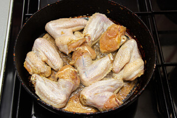 Fry chicken wings in a pan. Home cooking. Cooking chicken meat