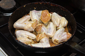 Fry chicken wings in a pan. Home cooking. Cooking chicken meat