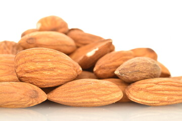 Several grains of peeled raw, organic almonds, close-up, isolated on white.
