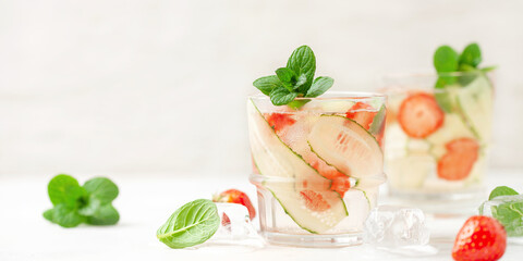 Summer refreshing iced drinks with cucumber,  strawberry and mint on white background