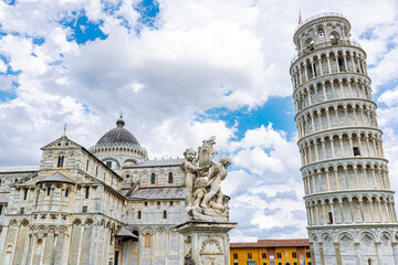 Fontana dei Putti, Tower and cathedral of the town of Pisa in Tuscany. On a cloudy day with blue sky.