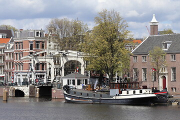 Amsterdam Amstel River View with Wooden Bridge, Buildings and Boat