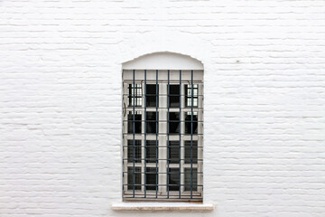 Vintage metal grid window white brick building wall