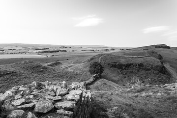 Fototapeta na wymiar Northumberland UK: Hadrians Wall built on tall cliffs (Roman Wall) on a sunny summer day in English countryside
