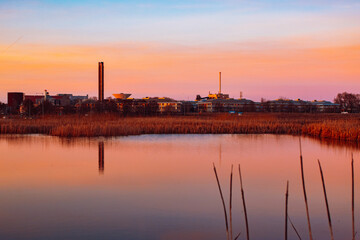 Obraz premium sunset in the city with industries in the background bringing pollution the air