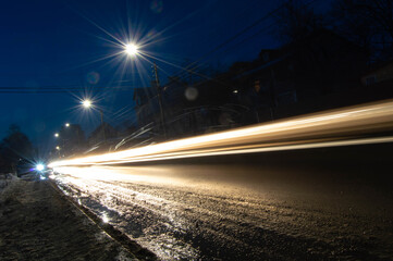 Fototapeta na wymiar night photo of blurred warm light from car headlights along the road