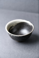 Fototapeta na wymiar Traditional ceramic bowl on gray background. Soft focus. Copy space. 