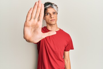 Young hispanic man wearing casual clothes doing stop sing with palm of the hand. warning expression with negative and serious gesture on the face.