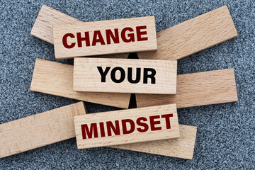 CHANGE YOUR MINDSET - words on wooden bars on a gray background with a free space.