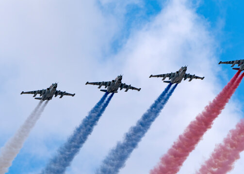 MOSCOW, RUSSIA - MAY 7, 2021: Avia parade in Moscow. Group of Russian fighters Sukhoi Su-25 with painted russian flag in the sky on parade of Victory in World War II in Moscow, Russia