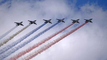 MOSCOW, RUSSIA - MAY 7, 2021: Avia parade in Moscow. Group of Russian fighters Sukhoi Su-25 with painted russian flag in the sky on parade of Victory in World War II in Moscow, Russia