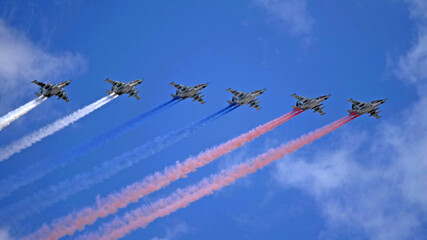 MOSCOW, RUSSIA - MAY 7, 2021: Avia parade in Moscow. Group of Russian fighters Sukhoi Su-25 with painted russian flag in the sky on parade of Victory in World War II in Moscow, Russia