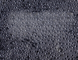 Water droplets gray background on window pane