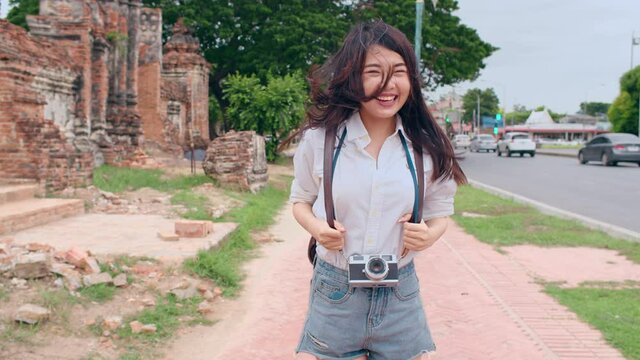 Young joyful Asian backpacker blogger woman tourist hold camera walk and run lead with happy smile excited travel in old city street. Couple traveller, Lifestyle tourist travel holiday concept.