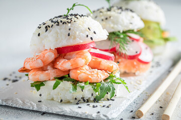 Healthy sush burger with seafood and vegetables sprinkled with sesame.