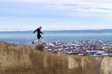 Man running in mountains and houses background