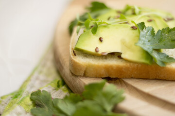 Sandwich with avocado slices and parsley