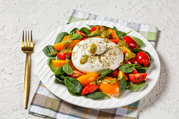 Spinach, Tomato and Burrata Salad on a plate