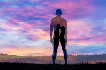 Silhouette man on grass with sunset background