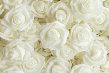 Obraz na płótnie Canvas background of white flowers. fake flowers. Artificial white roses, foamiran roses.
