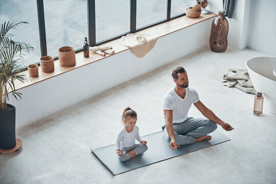 Top view of father and daughter doing yoga