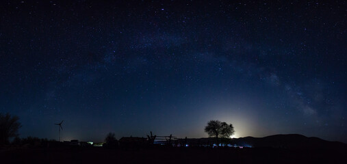 MilkyWay sky at night in the countryside with windmill