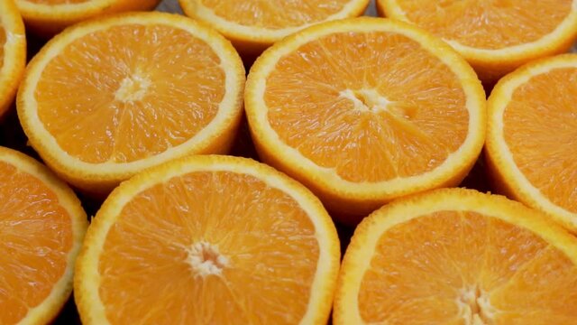 Fresh Juicy Slices Of Orange Halves, Close-up. Background of Sliced Slices, Halves of Oranges, Cirtus Tropical Fruits, Rotation. Healthy Vitamin Food.