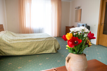 Hotel apartment interior. Interior of a hotel bedroom with flowers.